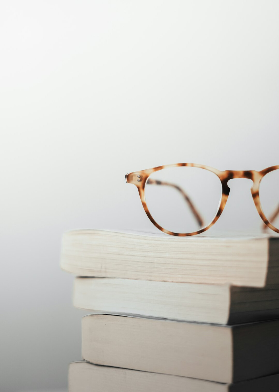 Stack of books with a pair of reading glasses on top