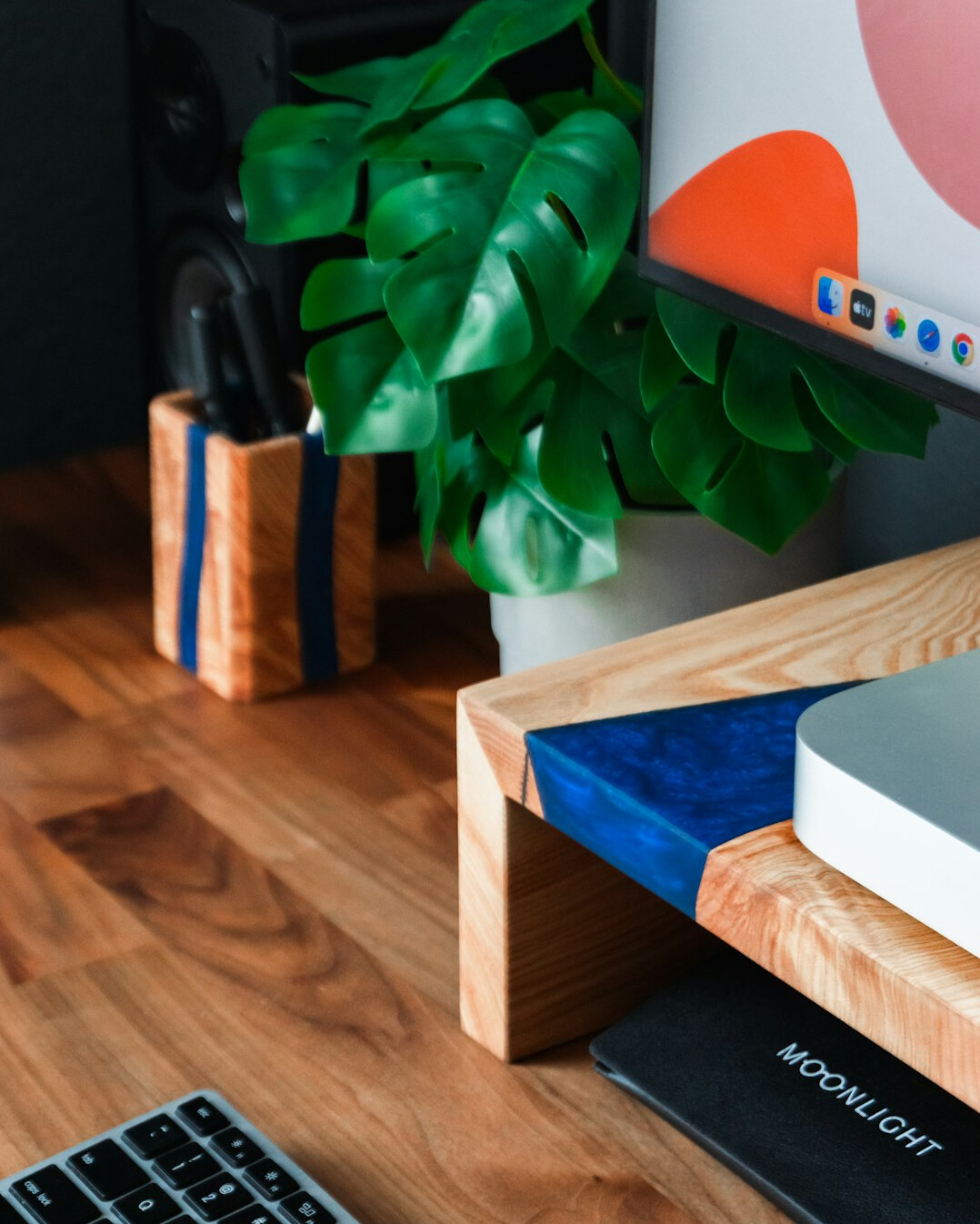 Minimalist home desk with an open notebook, plant and cup of coffee